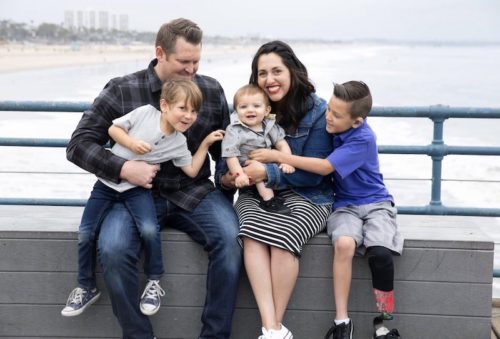 a photo of a happy family sitting on a dock on a pier