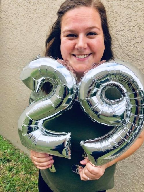 a photo of a smiling meagan with balloons with twenty-nine on them