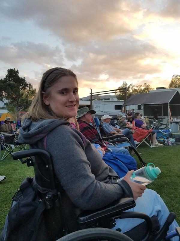 a photo of melissa simpson in a wheelchair at an outdoor event smiling