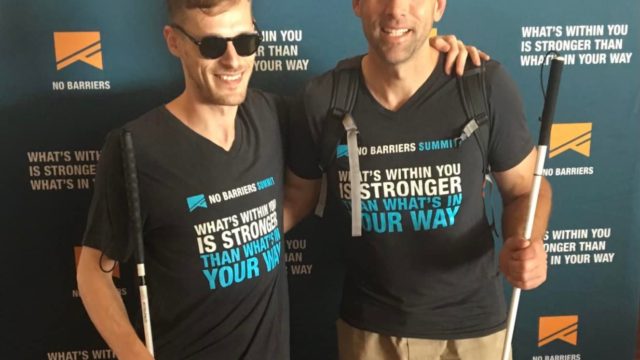 Erik and Casey at the 2017 No Barriers Summit holding canes and wearing No Barriers shirts.