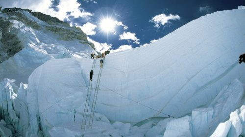 Erik and his team climb a set of ladders in the Khumbu Icefall.