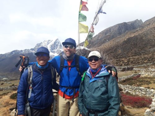 Me and teammates Nawng Chongba and Kami Tenzing in front of Lobuche (20,075') with prayer flags strung above our heads. Credit: Kami Tenzing.