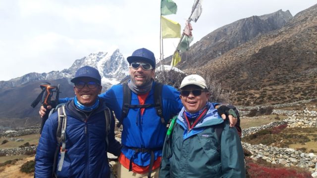 Me and teammates Nawng Chongba and Kami Tenzing in front of Lobuche (20,075') with prayer flags strung above our heads. Credit: Kami Tenzing.