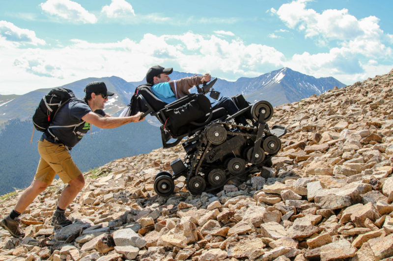 Erik Weihenmayer helps push Cole Rogers in his Action Trackchair toward the summit of Copper Mountain (12,300') during the 2016 No Barriers event, What's Your Everest