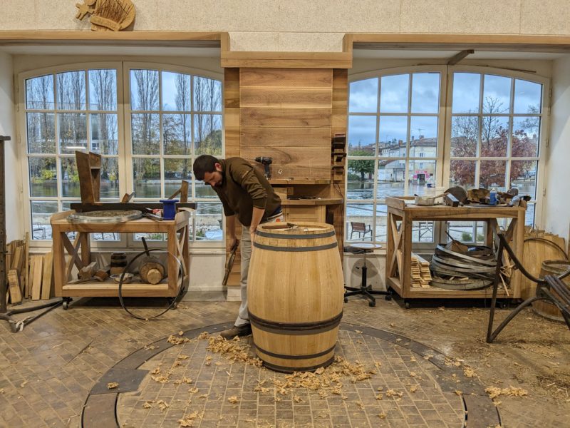 A cooper putting the finishing touches on a barrel. A cooper putting the finishing touches on a barrel. 